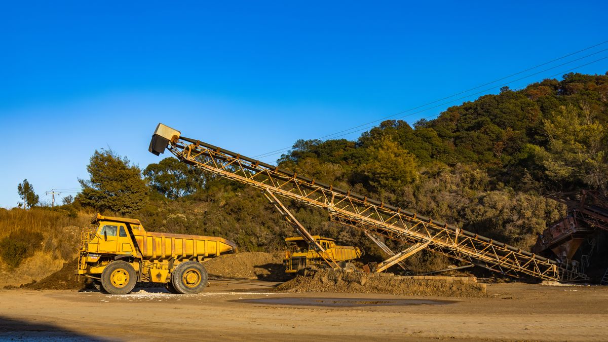 Radial stacker belt conveyor and haul truck at a quarry