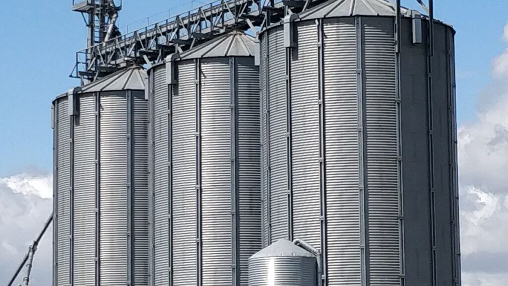 Steel grain silos against a blue sky