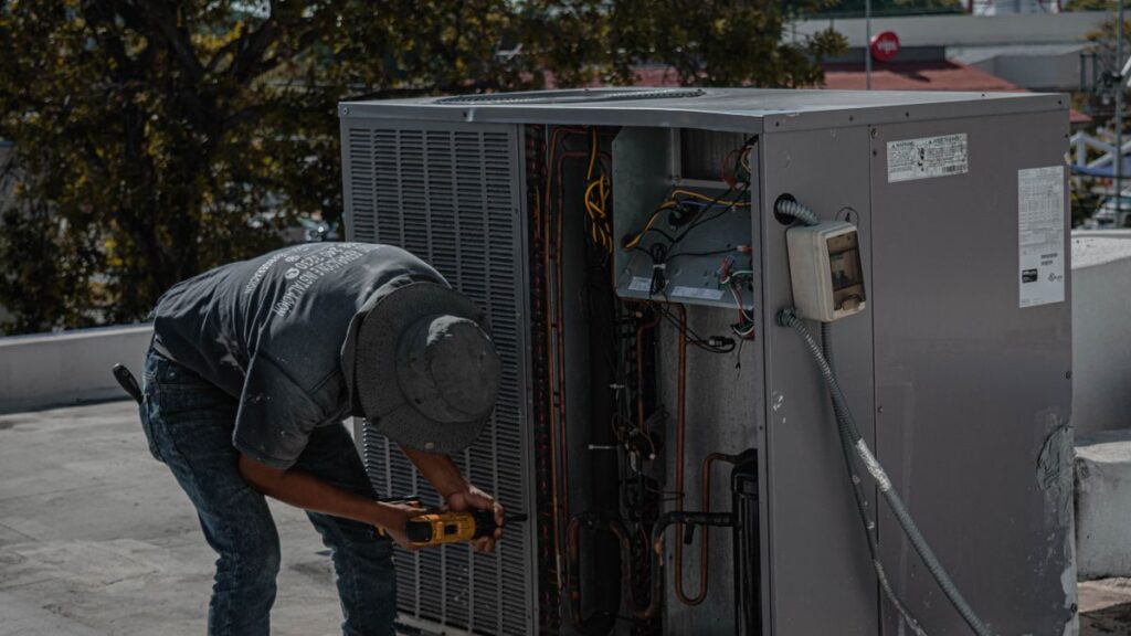 Technician servicing a rooftop HVAC unit